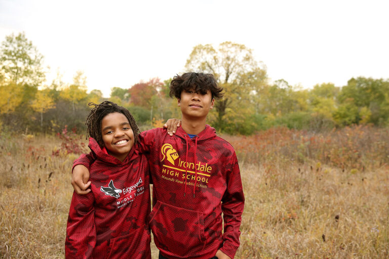two brothers photographed in red sweatshirts at rice creek fields